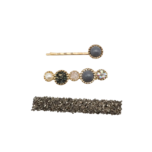 A set of three women's hair accessories clips, two with gold and grey design and one with a glittery brown band.