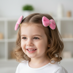 Load image into Gallery viewer, Child with pink hair bows in a neutral indoor setting
