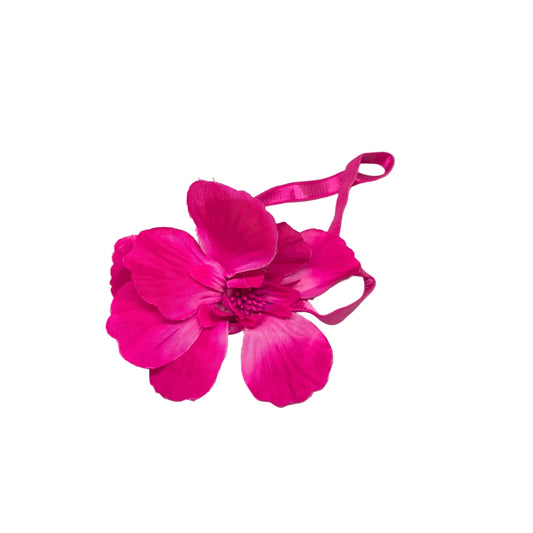 Pink floral hair clip on a white surface