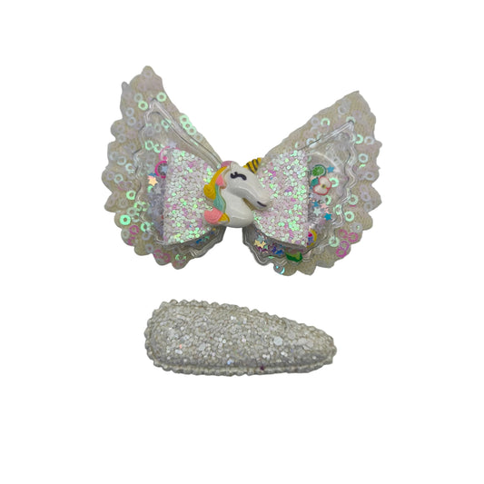 A children's hair accessory clip featuring a sequined unicorn design on a white background.