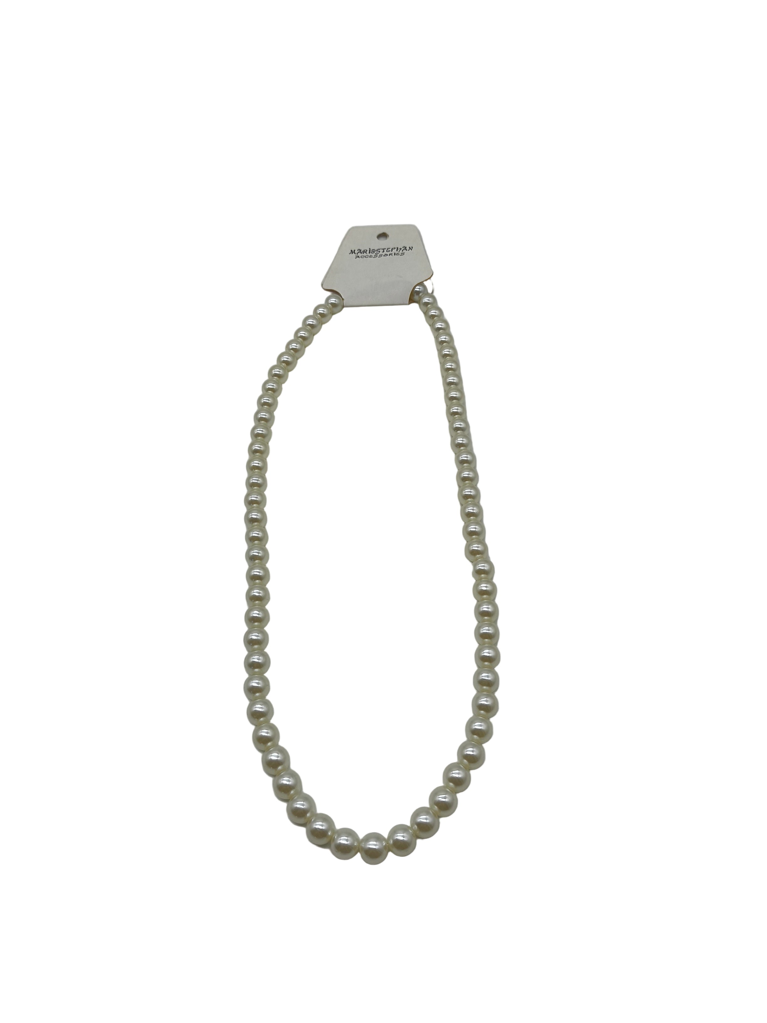Pearl necklace on a light gray background with a brand tag.