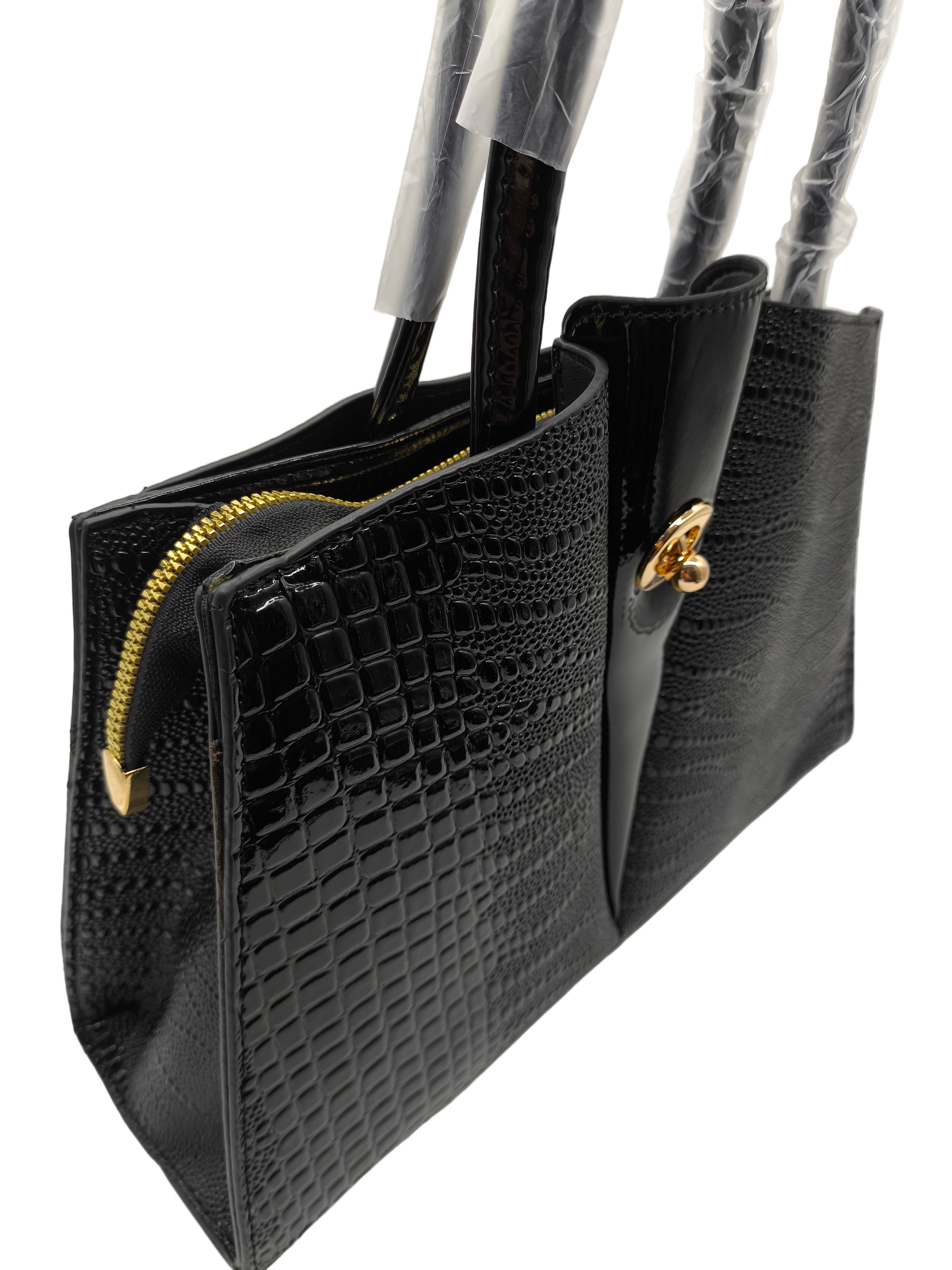 Black textured handbag with gold accents on a white surface