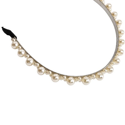 Close-up of alternating large and small ivory pearl-style beads on silver-tone headband